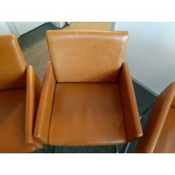 Cognac kleurige eetkamerstoelen.