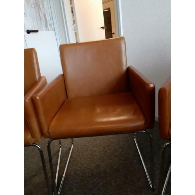 Cognac kleurige eetkamerstoelen.